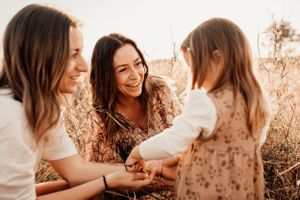 A heartwarming moment shared between friends in a golden sunlit field with warm sepia tones.