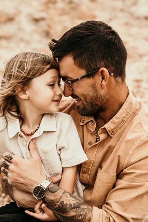 A tender close-up moment between two people with warm sepia tones in natural lighting.