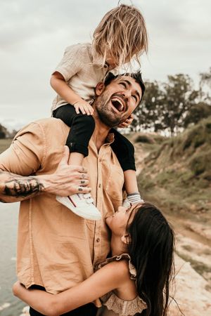 Joyful candid outdoor portrait showing playful embrace on coastal trail.