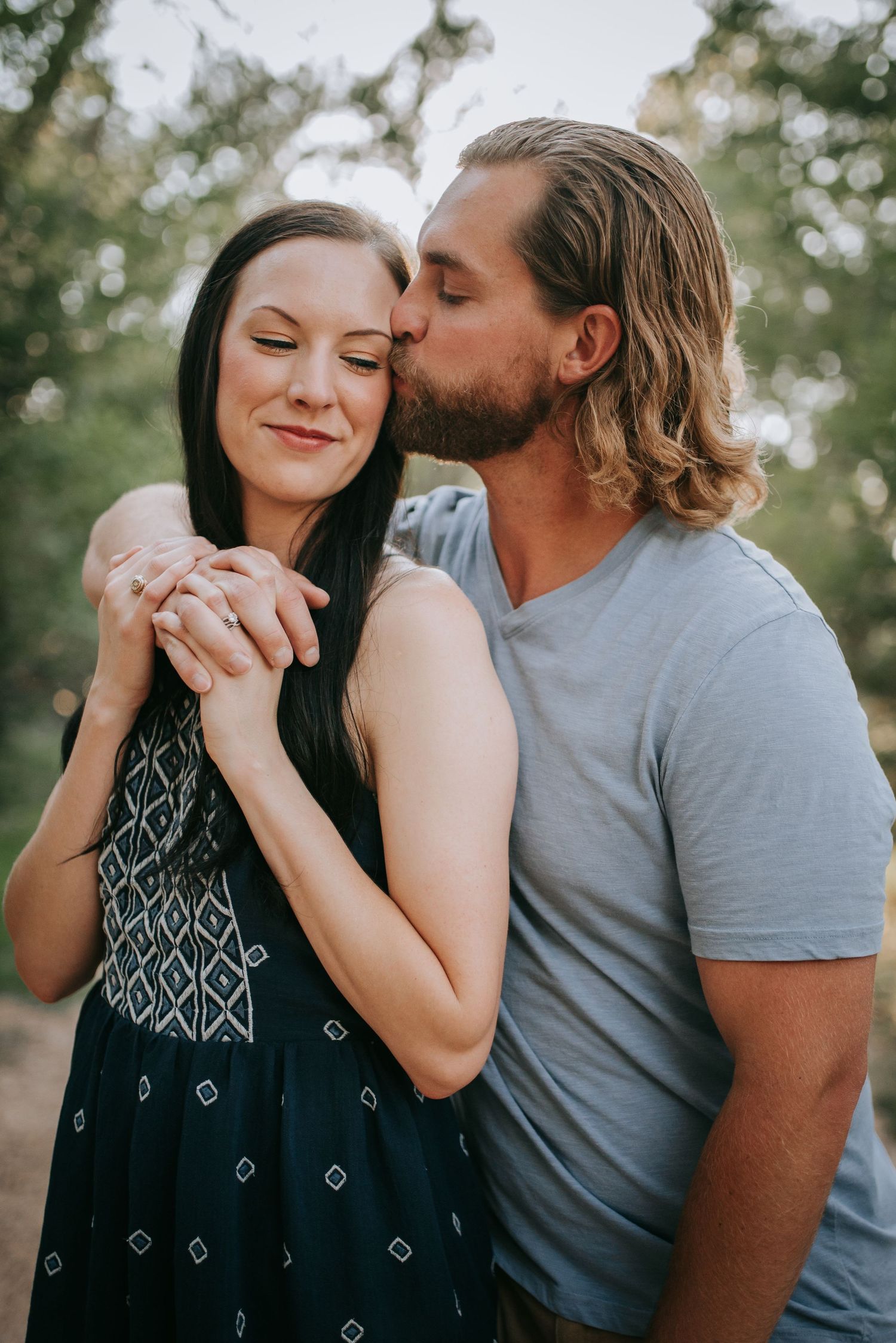 Intimate outdoor portrait of a couple sharing a tender moment in natural lighting.