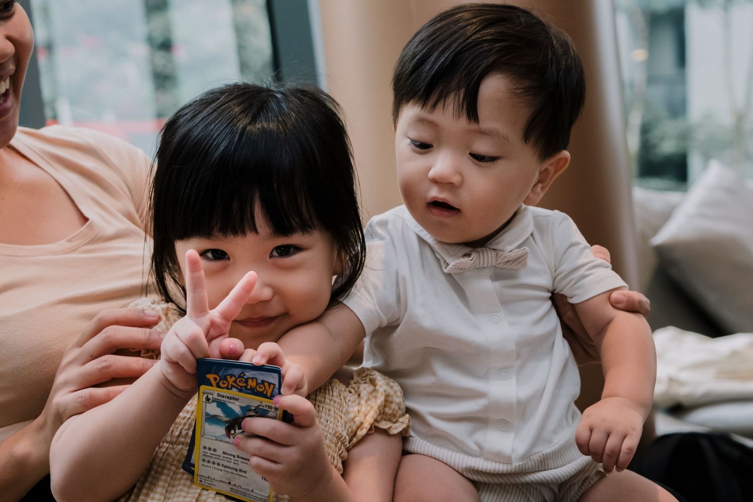Two young children sharing a snack together indoors.