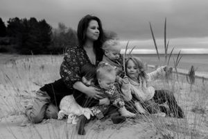 Family members sharing tender moments while relaxing in a grassy field.