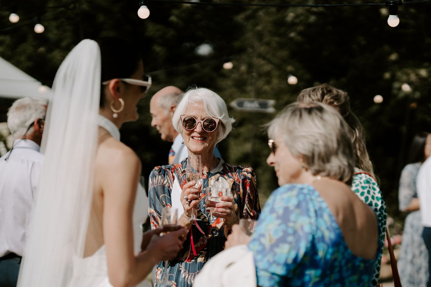 wedding guest smiling at bride outside marquee in islip, oxfordshire