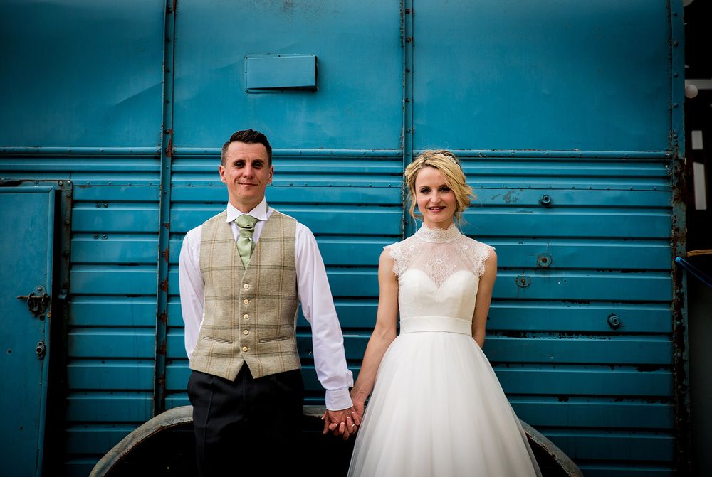 bride & groom against turquoise rice trailer
