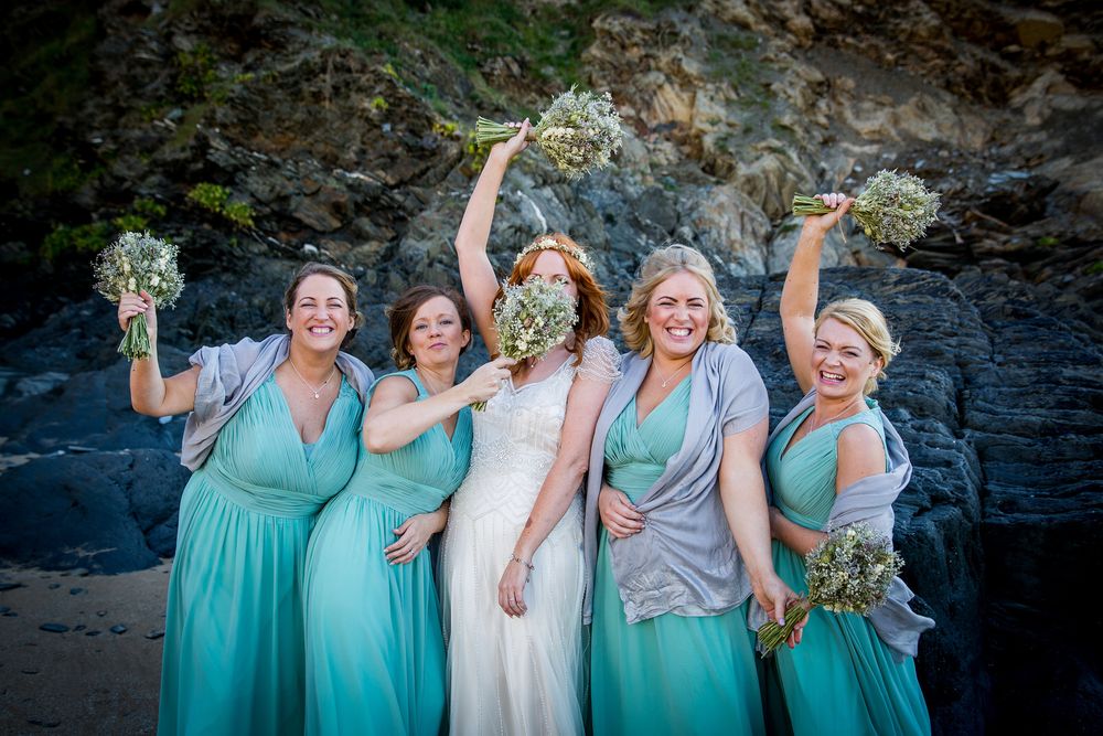 bridesmaids on a beach with bouquets