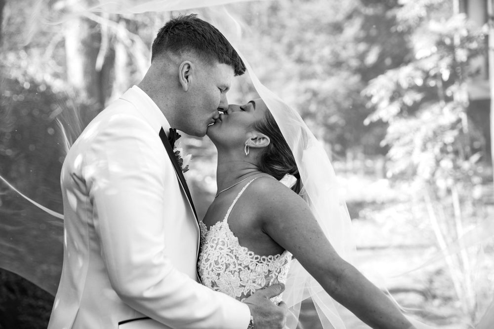 Bride and groom kissing under the veil