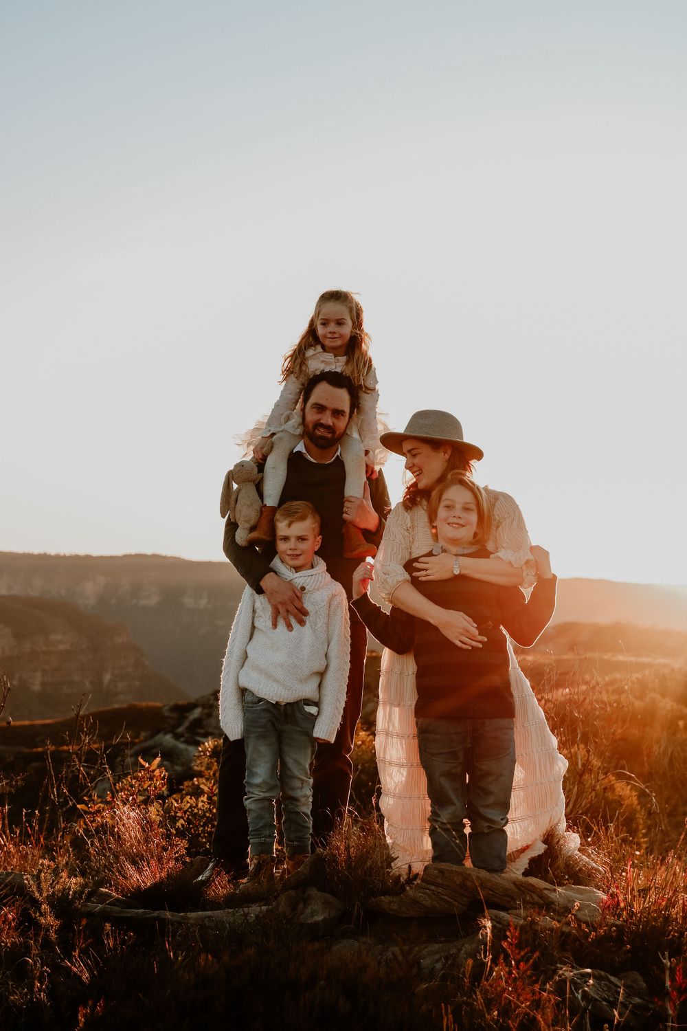 Family portrait session at sunset with mountain views in the background.