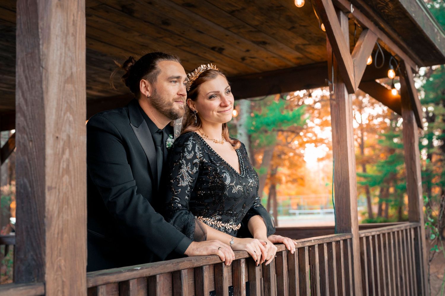 A couple sharing a romantic moment on a rustic wooden porch during autumn.