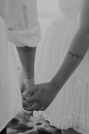 Black and white detail shot of hands reaching for each other.