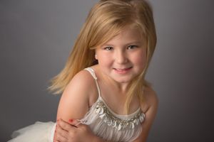 Studio portrait with soft lighting against grey background.