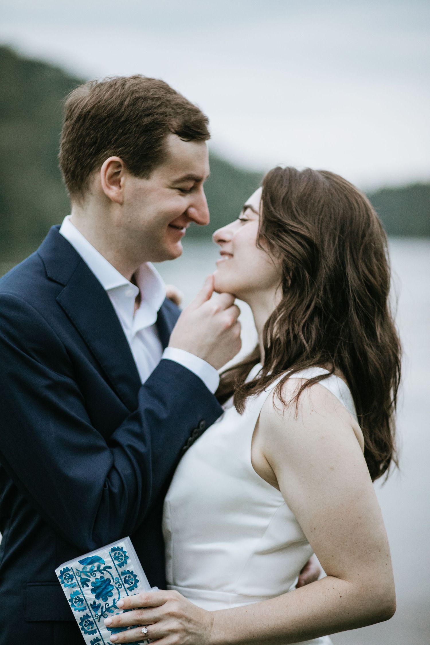Intimate wedding portraits of couple sharing tender moments by the water.