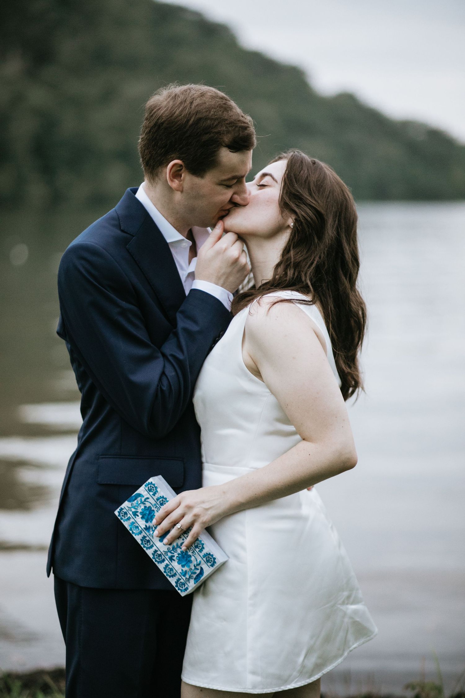 Romantic waterfront wedding photos of couple embracing by the shore.