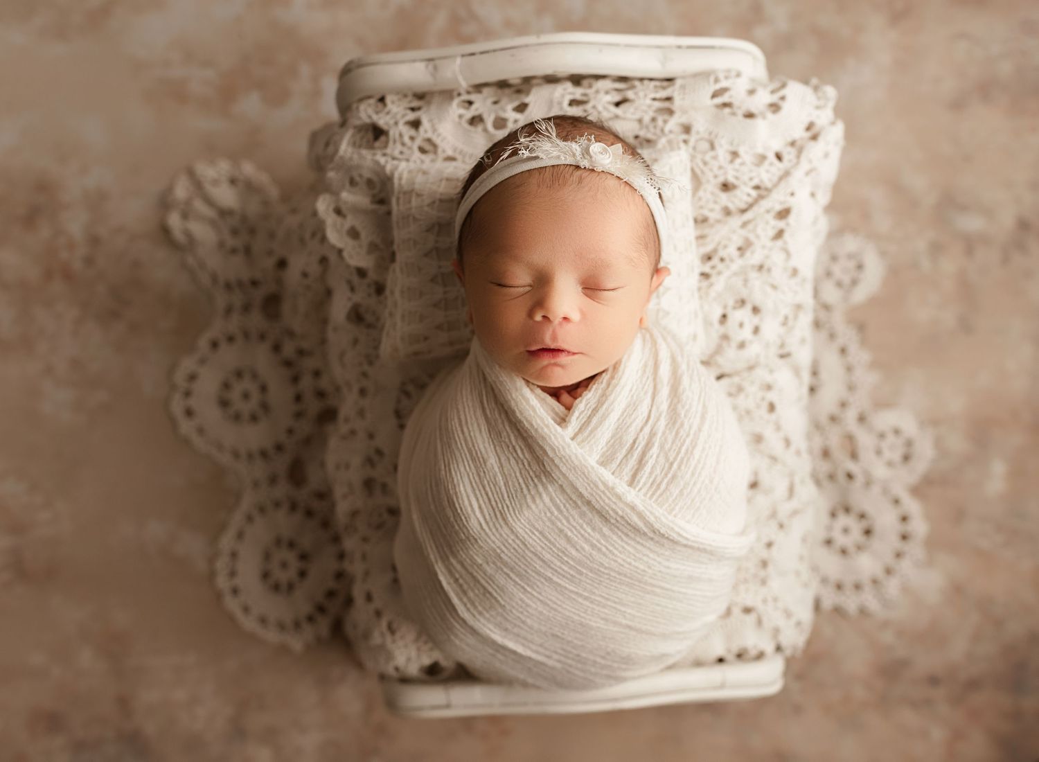 Best newborn photographers Riverside, baby girl in white swaddle against lace