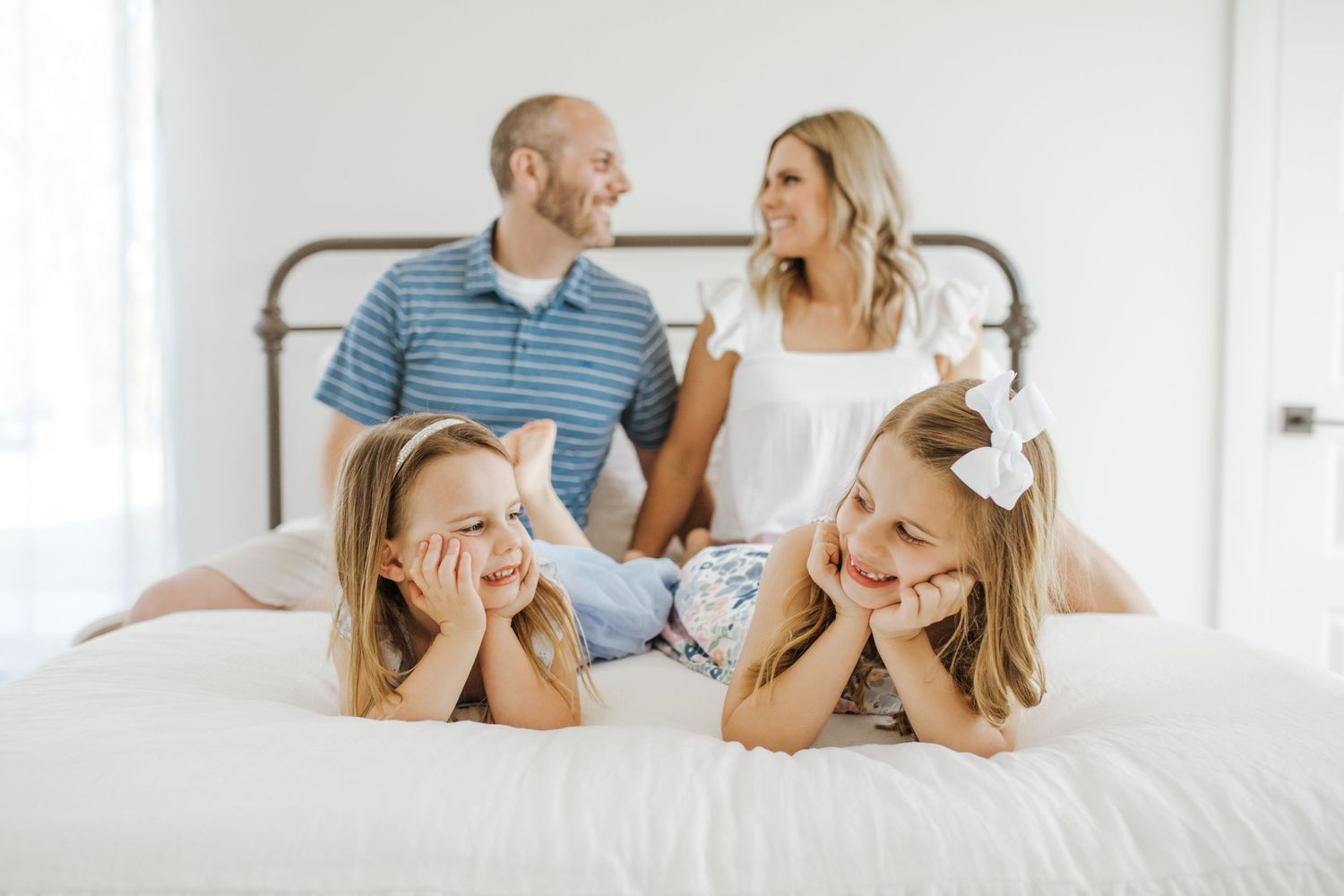 family of four with white background and everyone looking at each other