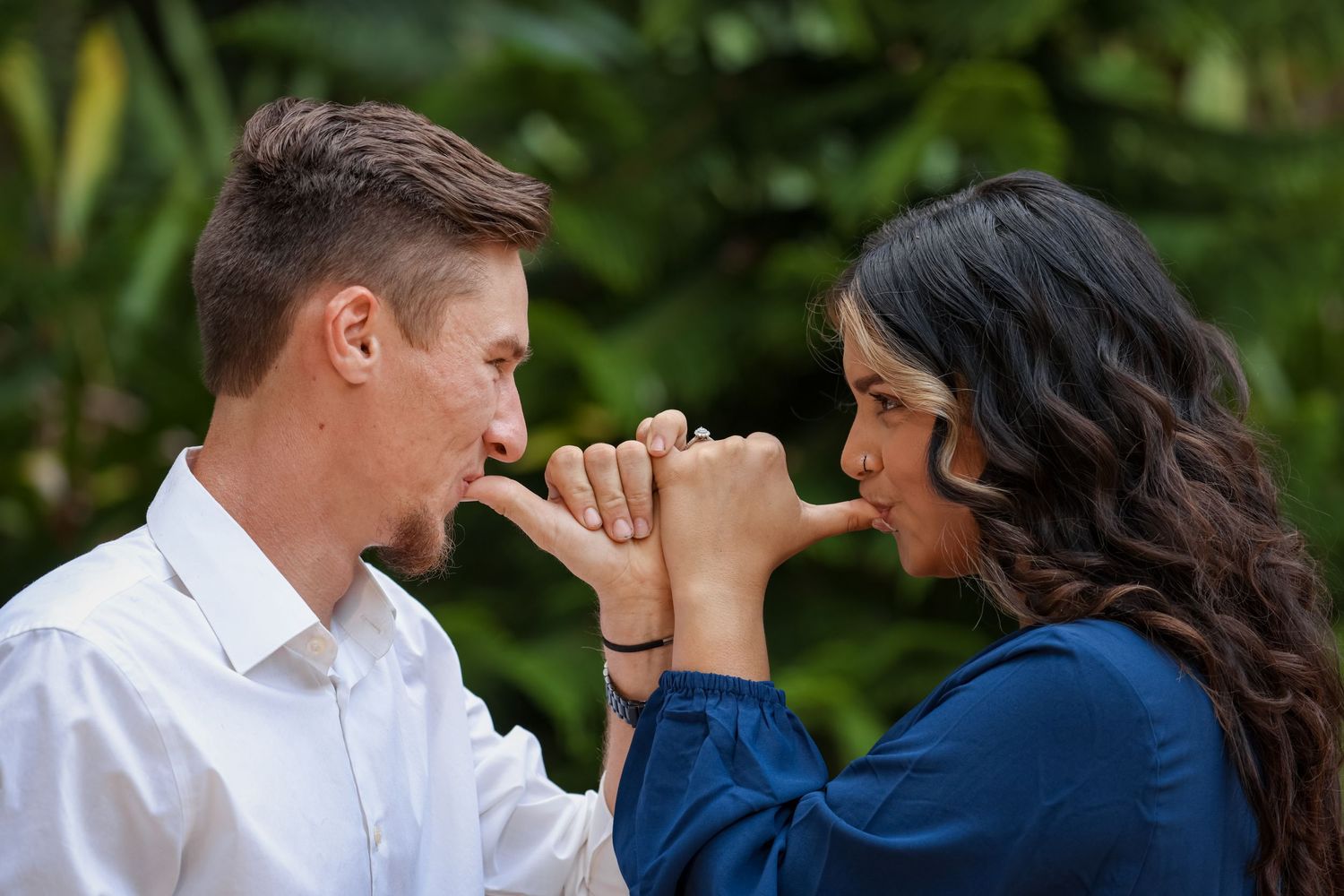 Playful engagement photo with couple sharing a pinky promise.