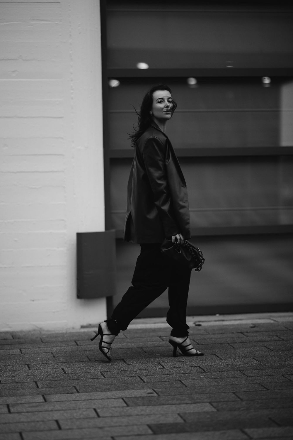 Stylish street fashion photo in black and white showing an oversized blazer and casual urban look.