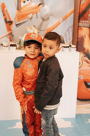 Two young children posing together at Cars themed birthday party.