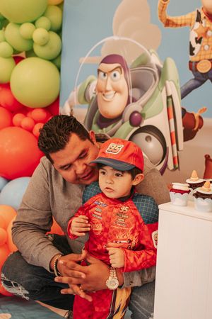 A Buzz Lightyear backdrop with colorful balloons creates a festive kids party atmosphere.