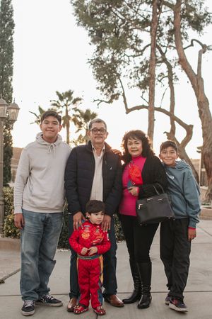A group portrait taken outdoors with palm trees and natural lighting at sunset.