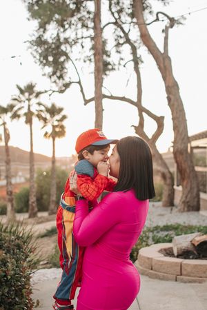 A sweet outdoor moment captured against a backdrop of palm trees and natural landscape.