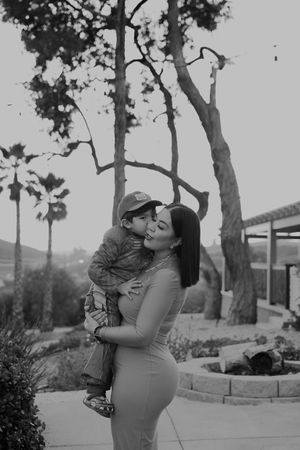 A tender black and white portrait captured outdoors with palm trees in the background.