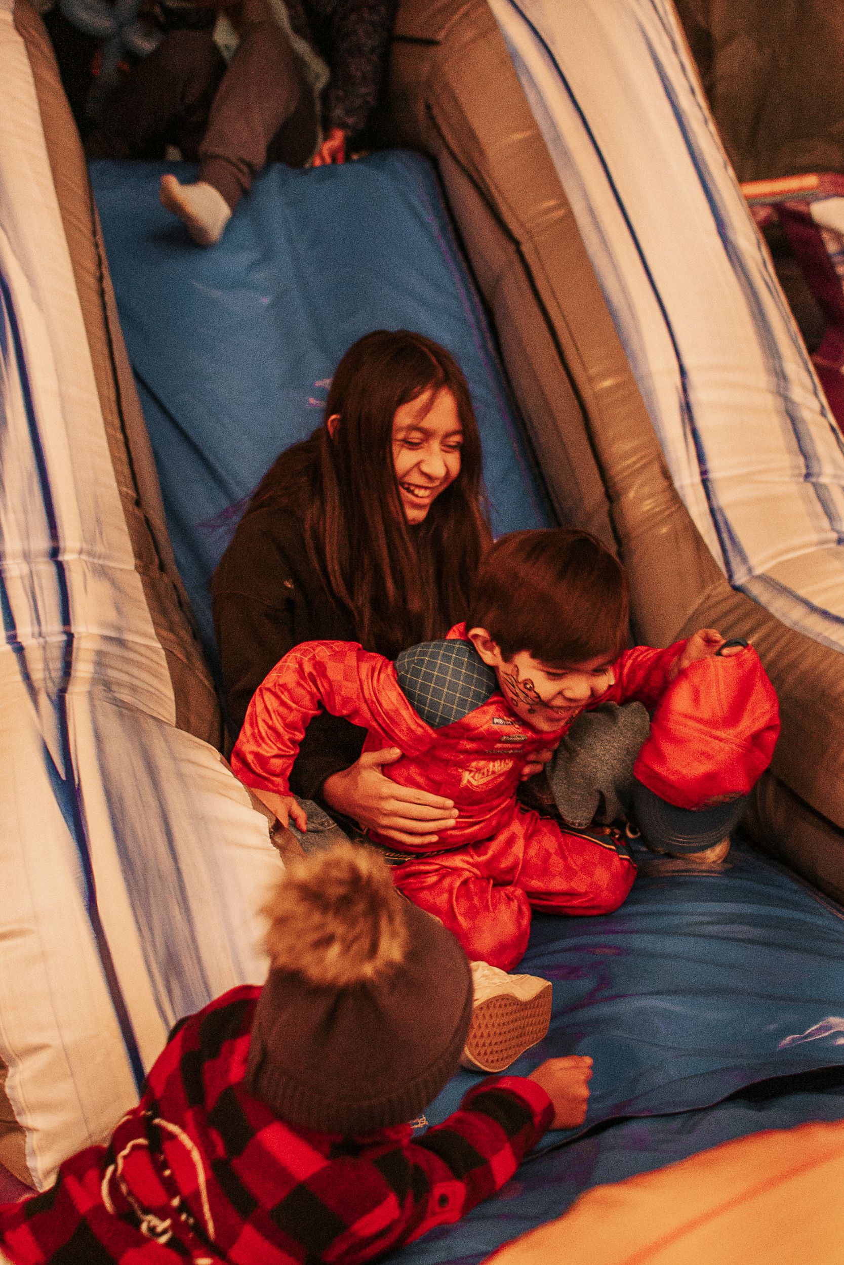 People enjoying a cozy moment inside a blue and white camping tent.