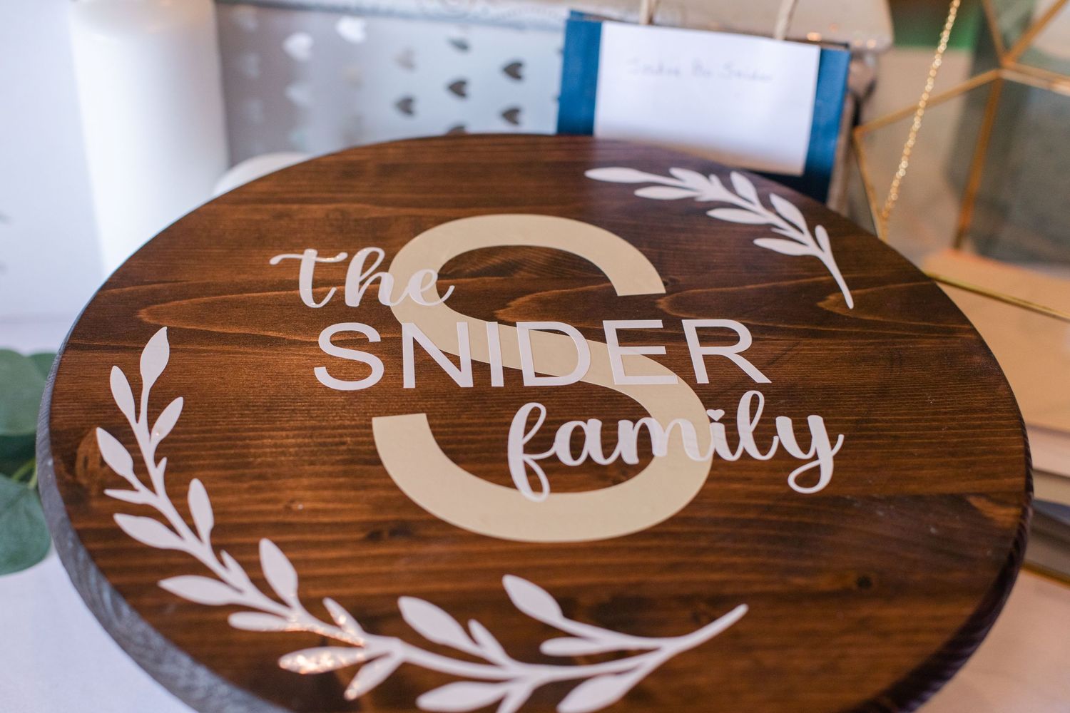 Rustic wooden signs with family names and decorative leaf designs for wedding decor.