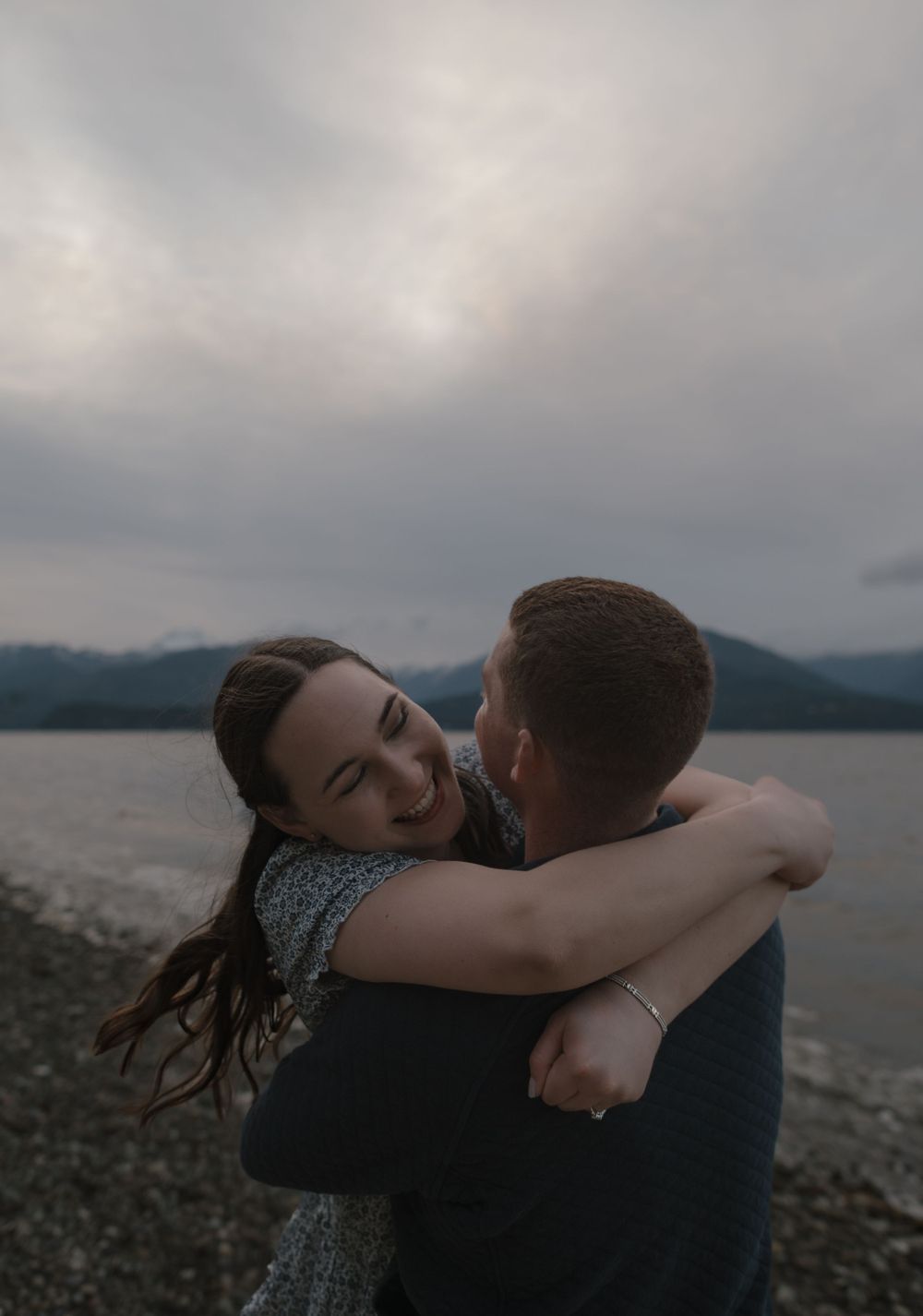 Intimate embrace captured during sunset at a scenic mountain lake.