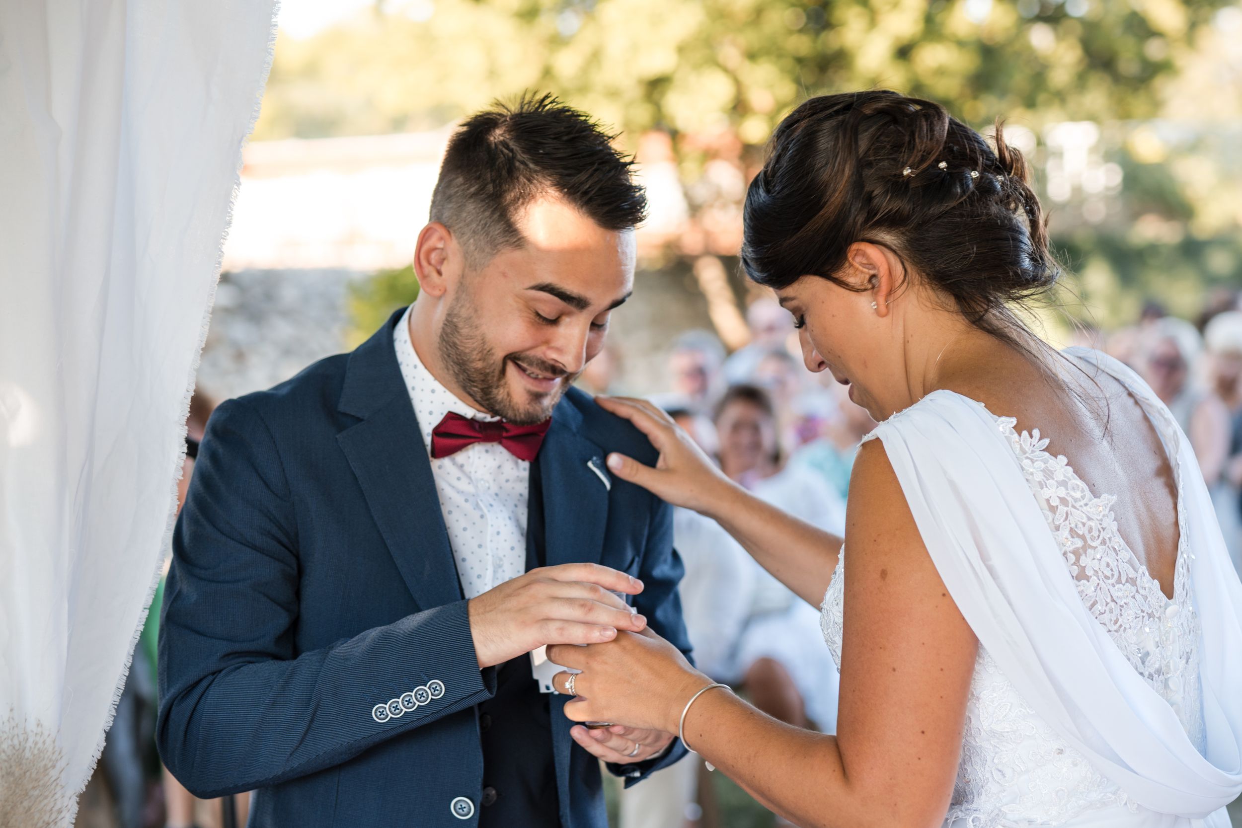 photo des mariés qui regardent leur bague de mariage ( alliance) et qui sont heureux