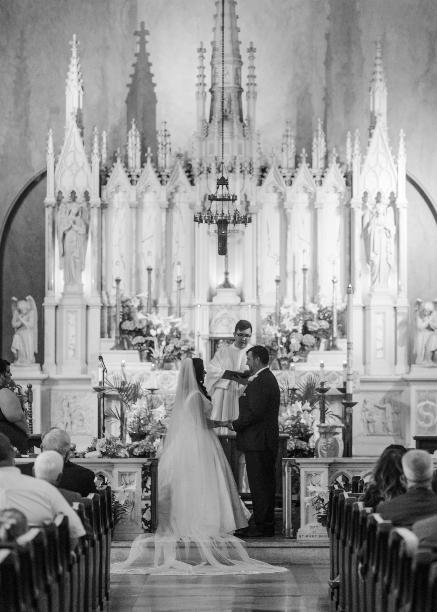 Black and white photo of traditional church wedding ceremony with Gothic architecture.