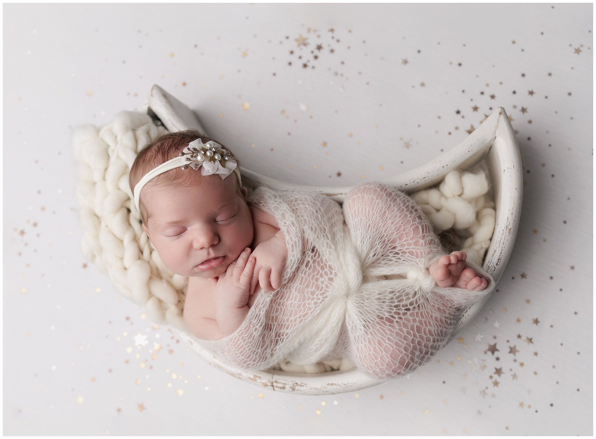 Newborn girl photo.  Posed swaddled in a white heart bowl on shimmery stars background. by valerie kay photography