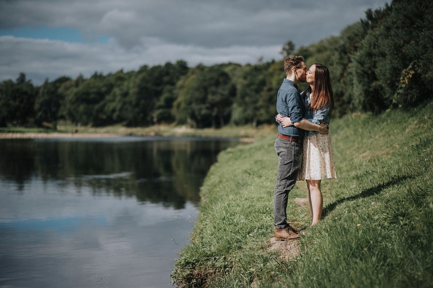 a couple kissing by a river