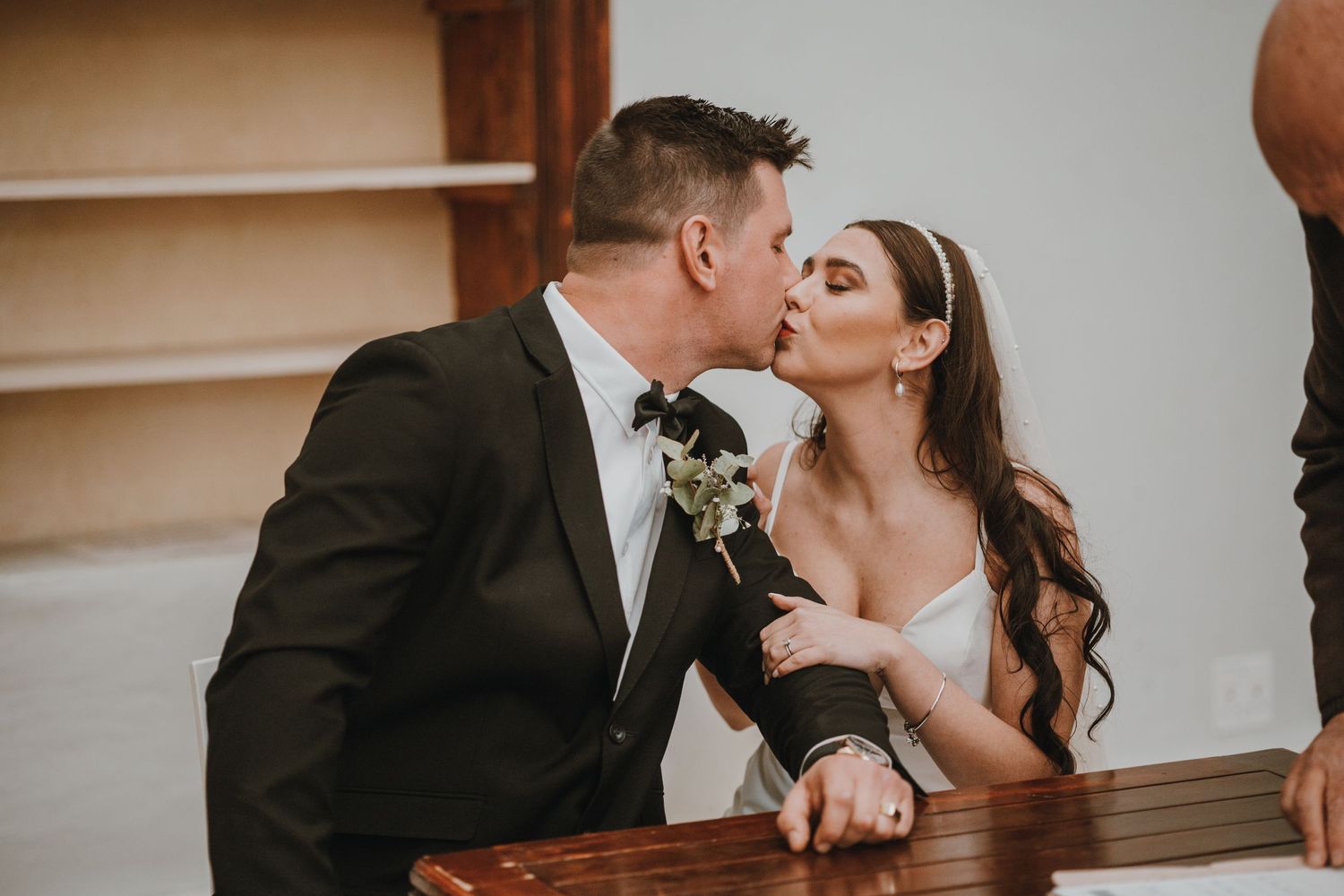 Intimate moment between couple in formal attire during wedding celebration.