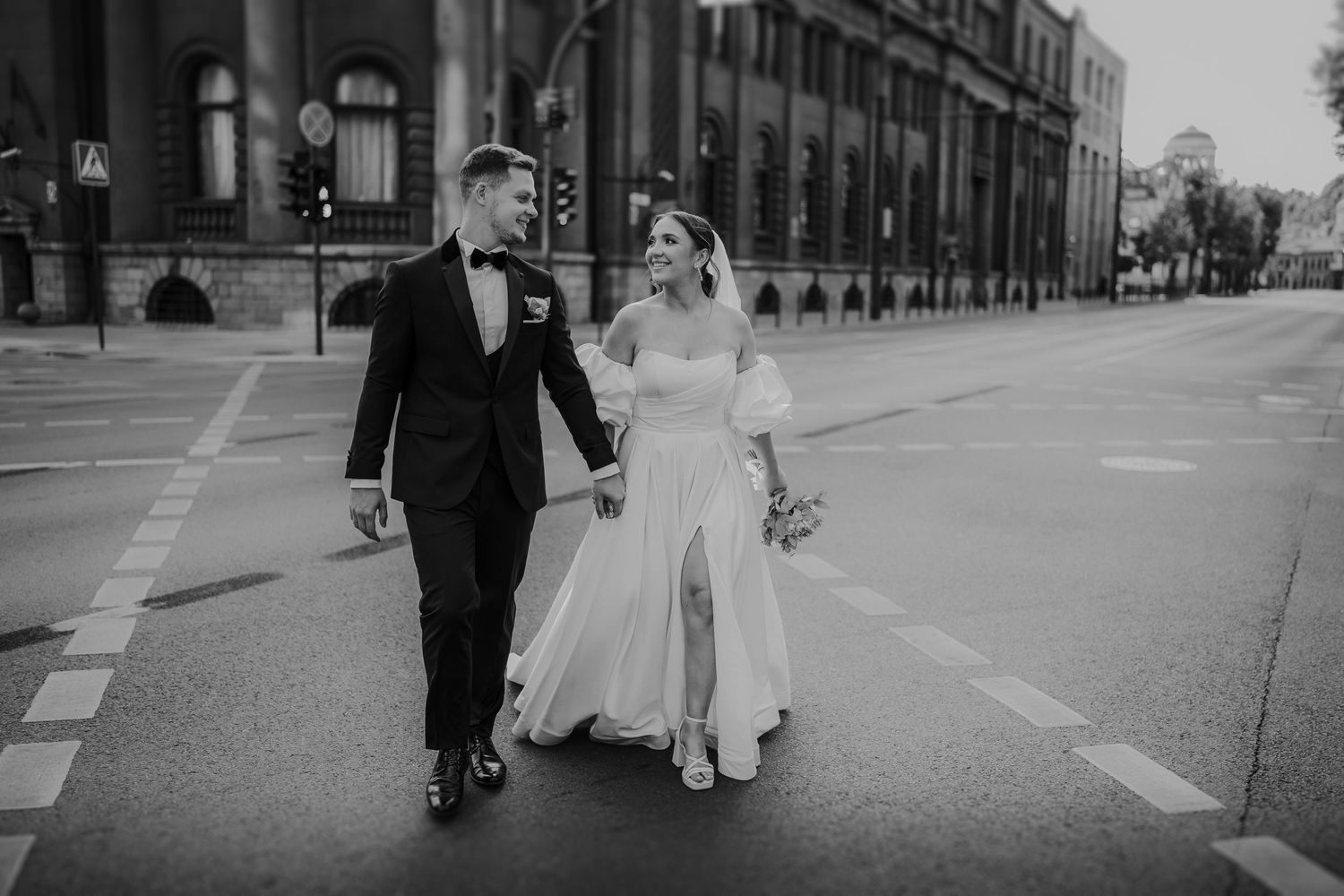 Black and white wedding photography sequence showing couple walking together on a city street.