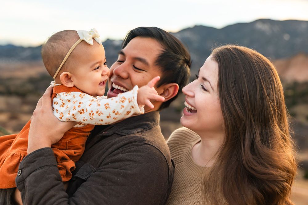 Joyful family moment captured against mountain backdrop at sunset.