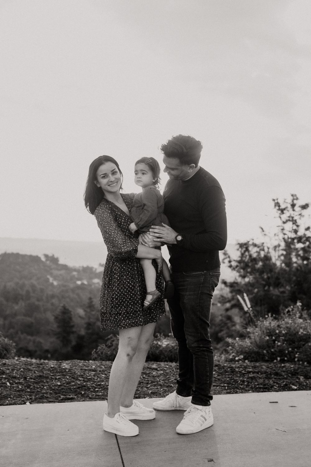 A black and white portrait of a family sharing a moment on an outdoor patio.