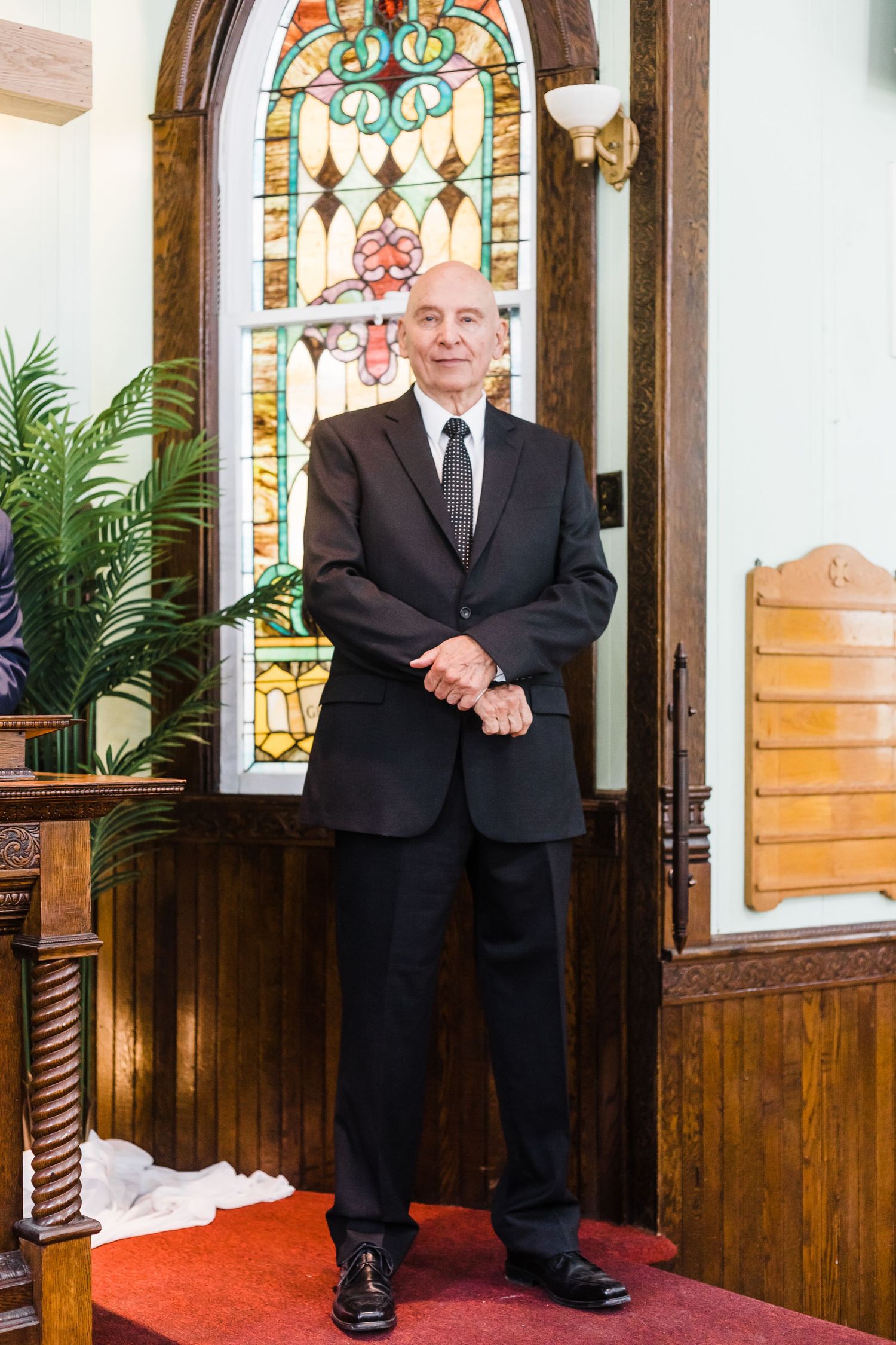 Elegant church interior with stained glass windows and decorative woodwork.