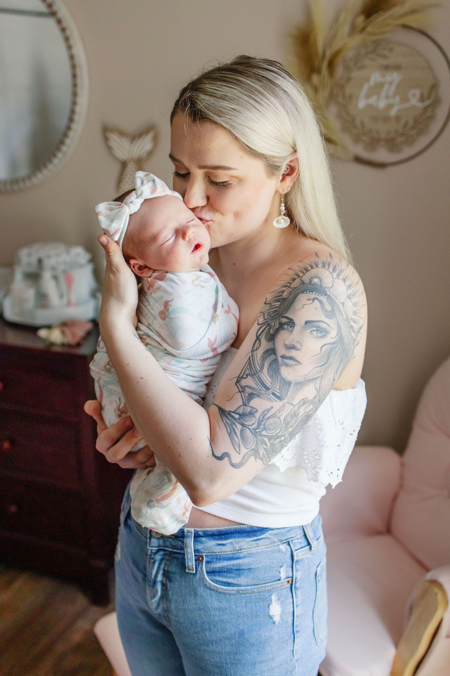 mom holding baby and kissing baby on the cheek