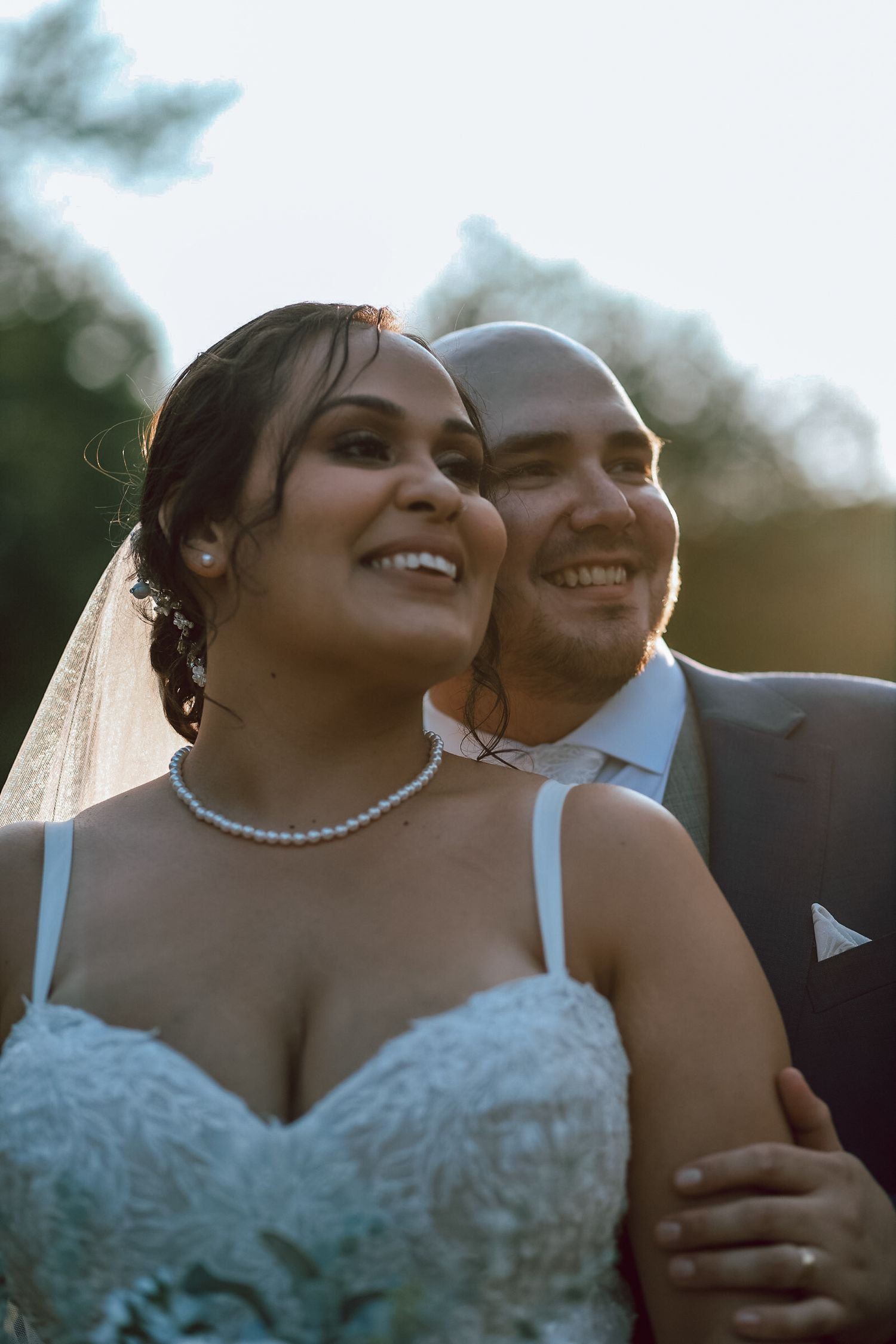 Sun-kissed portrait of newlyweds sharing intimate moment during golden hour.
