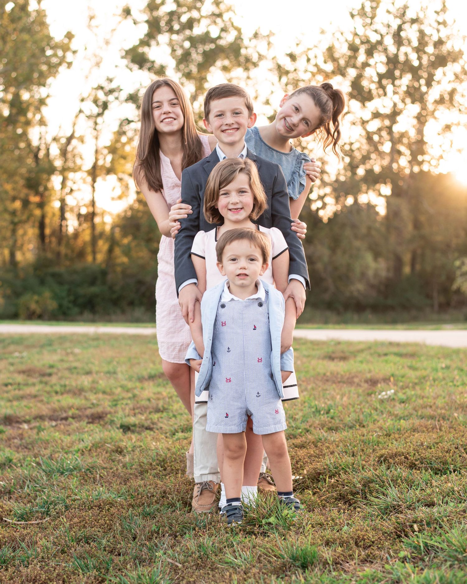 Five siblings holding each other's shoulders in this photo by St. Louis Photographer Isabel Nolan.