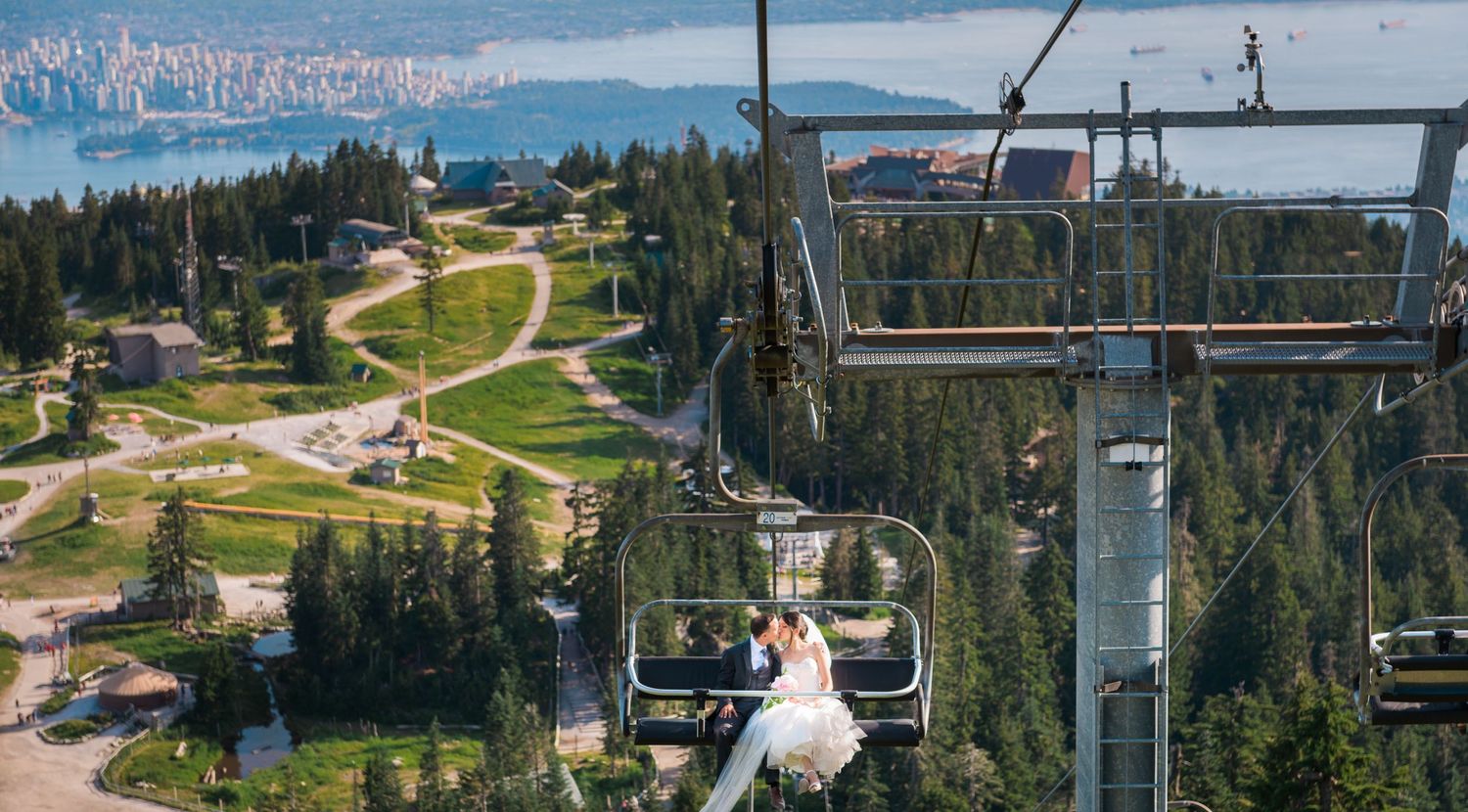 A chairlift ride reveals spectacular mountain views overlooking a ski resort with cityscape in the background.