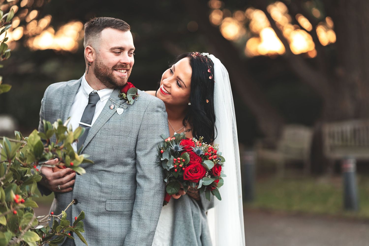 Bride and groom portrait at golden hour with red bouquet, outdoor couple wedding photography Southampton