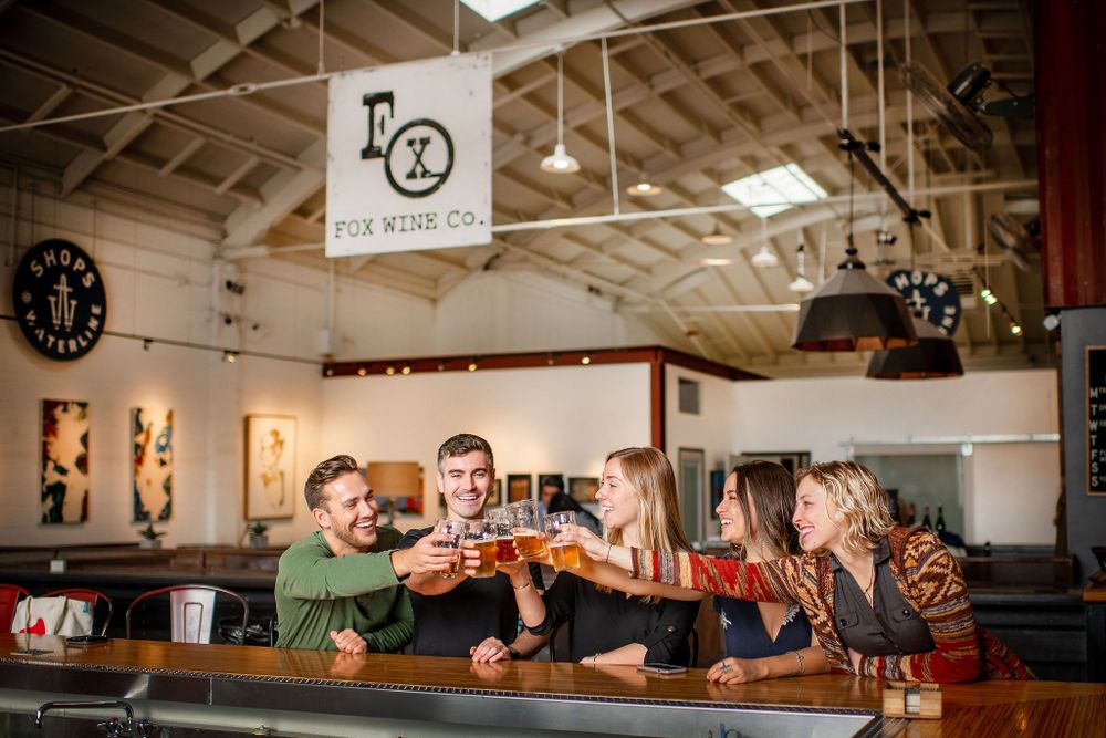 lifestyle photos of friends cheersing and laughing at topa topa brewery, santa barbara, ca