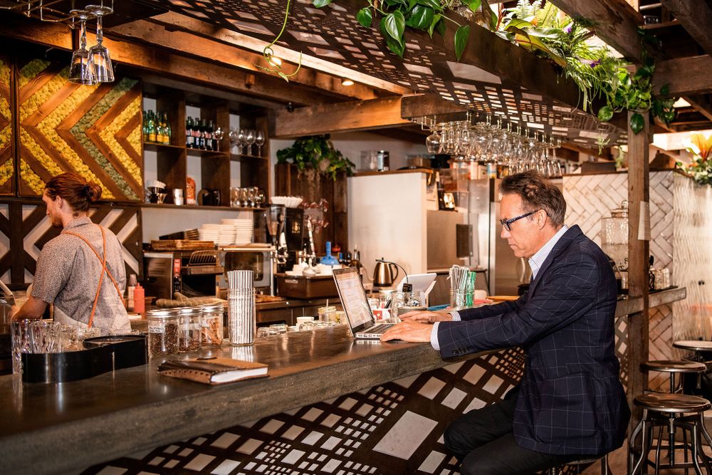 man sitting at a coffee bar doing some remote work in santa barbara ca