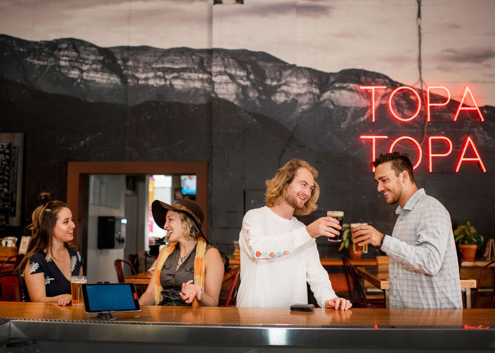 friends interacting in a social scene at topa topa brewery in santa barbara, ca