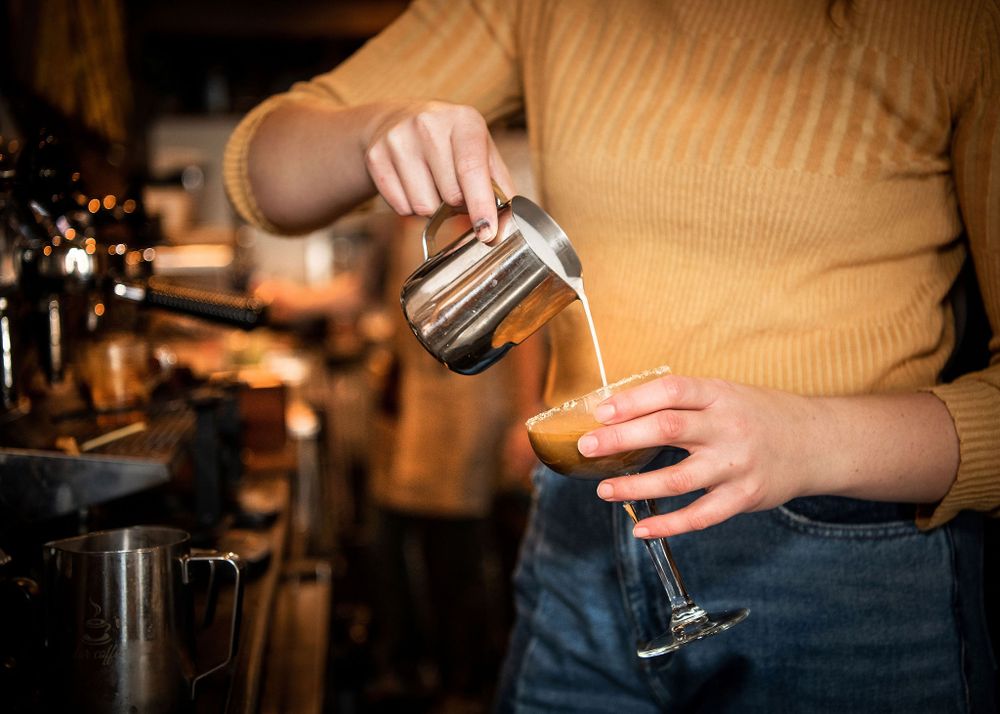 barista pouring coffee into a drink at caje coffee, santa barbara, ca