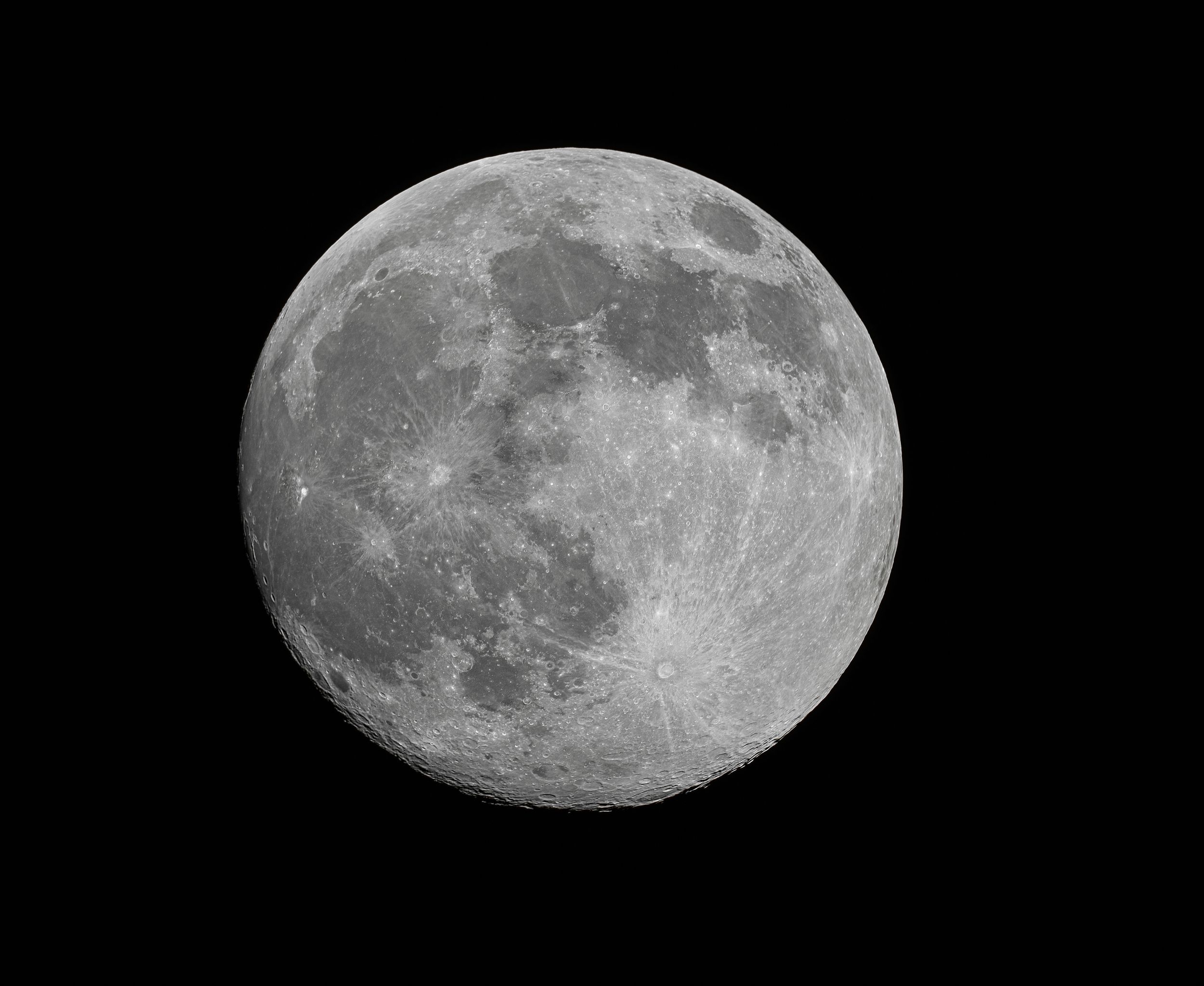 A bright full moon photographed in sharp detail against a black sky background.