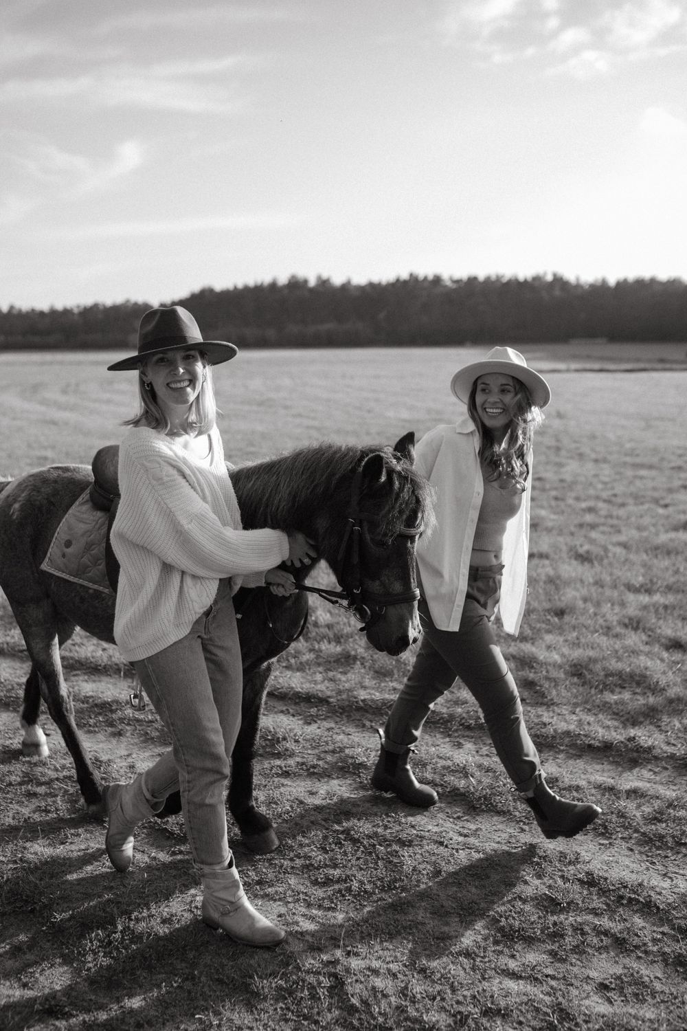 Black and white image of people playing leapfrog in a grassy field.