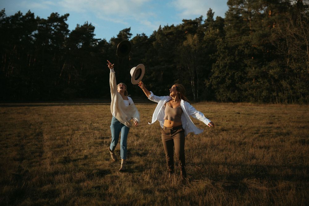 Silhouettes of people playing and jumping in a field at dusk.