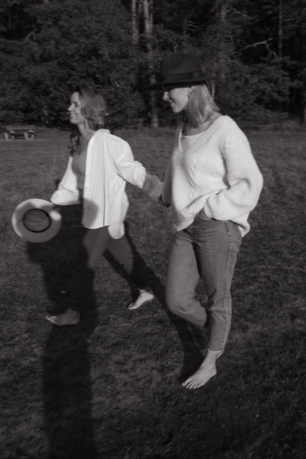 Dynamic movement captured in black and white as people dance in an outdoor field.